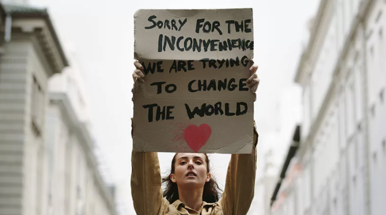 A Gen Zer holds a sign during a protest